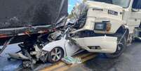 Carro &eacute; prensado por carreta e caminh&atilde;o-ba&uacute; em rodovia de MG neste domingo, 20; v&iacute;timas tiveram apenas ferimentos graves  Foto: Divulga&ccedil;&atilde;o/CBMMG