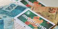 Cartelas da Mega-Sena e dinheiro. Foto: Reprodução / Portal de Prefeitura
