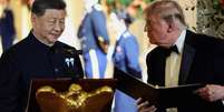 O presidente dos EUA, Donald Trump, segura uma pasta ao lado do presidente chinês, Xi Jinping, antes de Xi proferir um discurso durante um jantar de Estado na Casa Branca, em Washington, D.C., EUA, em 24 de setembro de 2026.  Foto: REUTERS - Evelyn Hockstein / RFI