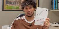 Foto: Reprodu&ccedil;&atilde;o/YouTube/Canal do Scarpinha - Legenda: GUstavo Scarpa indicando leitura aos seus f&atilde;s / Jogada10