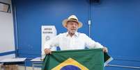 Lula posou com bandeira do Brasil após votar no último domingo, 4  Foto: WERTHER SANTANA/ESTADÃO CONTEÚDO/ESTADÃO CONTEÚDO