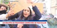 A rep&oacute;rter Ana&iuml;s Mar&eacute;chal se desvencilha dos cartazes colocados &agrave; sua frente para tentar trabalhar  Foto: Reprodu&ccedil;&atilde;o