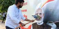 Manifestante rasga cartaz com a imagem do premi&ecirc; Narendra Modi, em Nova D&eacute;li. (10/10/2026)  Foto: RFI