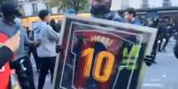 Foto: Reprodu&ccedil;&atilde;o de v&iacute;deo - Legenda: Manifestante exibe rel&iacute;quia de Messi roubada de uma loja durante protestos em Paris / Jogada10