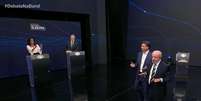 Um dos momentos tensos do debate na Band: os mediadores Adriana Ara&uacute;jo e Eduardo Oinegue precisaram erguer a voz para Fl&aacute;vio Bolsonaro (PL), Lula (PT) e a plateia no est&uacute;dio  Foto: Reprodu&ccedil;&atilde;o