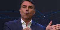 Flávio mostra a palavra 'corrupto' na mão  Foto: Reprodução/YouTube/Band 