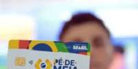 Pessoa segurando cart&atilde;o do P&eacute;-de-Meia. Foto: MEC/Divulga&ccedil;&atilde;o / Portal de Prefeitura