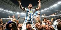 Oito jogadores autografaram o troféu que Messi ergueu em 2022 e que irá a leilão. Foto: Divulgação / Jogada10