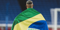 Jogador Richarlison publicou no Instagram uma foto enrolado na bandeira do Brasil pedindo consciência para votação no domingo  Foto: Reprodução / Instagram