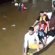 Moradores fazem 'corrente humana' para resgatar pessoas ilhadas