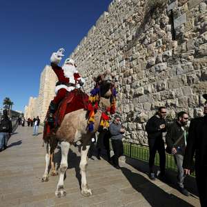 Papai Noel entrega árvores de Natal de camelo em Jerusalém