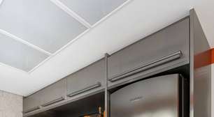 Cozinha ganha projeto moderno com acabamentos em inox e fórmica laranja