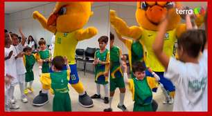 Menino Gui dança com o mascote da Seleção Brasileira antes do jogo contra a Argentina