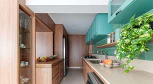 Cozinha com armários e revestimentos verde azulados é o charme deste apê