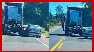 Caminhão arrasta carro enquanto motorista se pendura na janela e tenta agredir caminhoneiro no PR