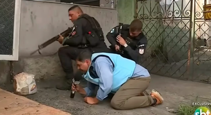 Repórter do SBT se protege atrás de policiais durante tiroteio no Rio