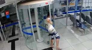 Ladrão invade banco, entala em porta giratória e é preso em MG