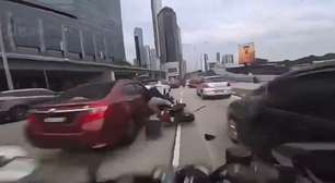 Criança abre porta de carro durante engarrafamento e derruba motociclista; veja vídeo