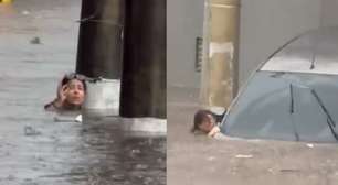 Mulher abandona carro e se agarra em poste para não ser levada pela água durante enchente em Guarulhos