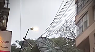 Vídeo inusitado: Ventos fortes arremessam caixa d'água sobre fiação elétrica no centro de Porto Alegre