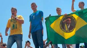 Com bandeira do Brasil com imagem do pai, Flávio diz que Bolsonaro lhe entregará faixa presidencial