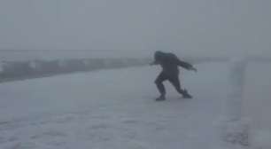 Homem luta para andar contra vento de 160 km/h