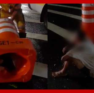 Homem e resgatado por agentes da CET apos ficar entalado em cone de transito em SP