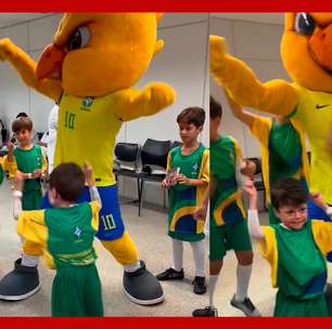 Menino Gui dança com o mascote da Seleção Brasileira antes do jogo contra a Argentina