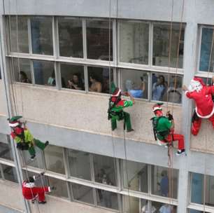 Papai Noel e ajudantes descem de rapel a fachada do Hospital de Clinicas em Porto Alegre