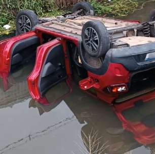 Carro roubado de motorista de aplicativo é encontrado capotado dentro de rio na CIC; veja vídeo