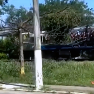Passageiros viajam segurando em portas e janelas em trem da Baixada Fluminense