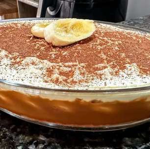 Torta banoffee montada na travessa com camadas generosas de doce de leite e banana