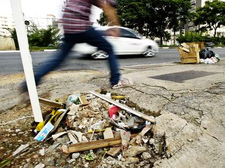 Pedestre salta por cima de um buraco na calçada da avenida Engenheiro Luís Carlos Berrini, em São Paulo <p>Pedestre salta por cima de um buraco na calçada da avenida Engenheiro Luís Carlos Berrini, em São Paulo</p>