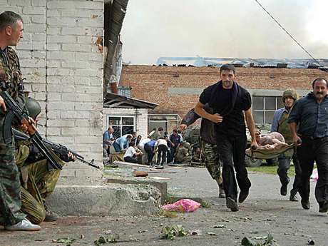 Militares esperam passagem de feridos durante operação de resgate no ataque à escola de Beslan em 2004 Militares esperam passagem de feridos durante operação de resgate no ataque à escola de Beslan em 2004