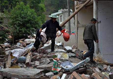Moradores de Lushan procuram pertences em meio aos destroços de sua casa, que foi destruída pelo tremor Moradores de Lushan procuram pertences em meio aos destroços de sua casa, que foi destruída pelo tremor