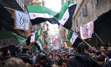 Rebeldes sírios marcham em Aleppo, cidade-berço da revolta contra Assad, com a antiga bandeira síria, símbolo do levante que se tornou guerra civil Rebeldes sírios marcham em Aleppo, cidade-berço da revolta contra Assad, com a antiga bandeira síria, símbolo do levante que se tornou guerra civil