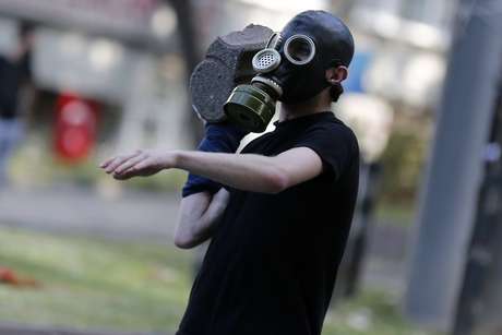Homem se prepara para atirar uma pedra na polícia de choque <p>Homem se prepara para atirar uma pedra na polícia de choque</p>