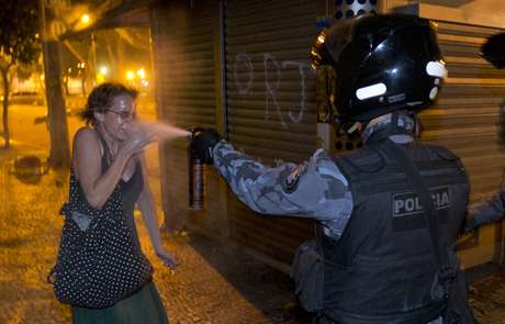 Policial militar joga gás de pimenta no rosto de uma mulher durante o protesto no Rio de Janeiro <p>Policial militar joga gás de pimenta no rosto de uma mulher durante o protesto no Rio de Janeiro</p>