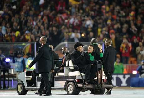 Mandela e a sua mulher, Graça Machel, acenam ao chegarem para cerimônia de encerramento da Copa do Mundo de 2010 no estádio Soccer City, em Soweto, em 11 de julho Mandela e a sua mulher, Graça Machel, acenam ao chegarem para cerimônia de encerramento da Copa do Mundo de 2010 no estádio Soccer City, em Soweto, em 11 de julho