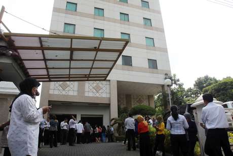 Funcionários de empresa em Medan aguardam do lado de for a de edifício após o terremoto Funcionários de empresa em Medan aguardam do lado de for a de edifício após o terremoto
