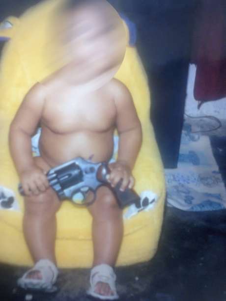 Foto de bebê segurando uma arma foi encontrada na casa de um dos suspeitos presos em Fortaleza (CE) Foto de bebê segurando uma arma foi encontrada na casa de um dos suspeitos presos em Fortaleza (CE)