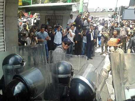 Luis Cruz / Reforma magen de un manifestante golpeando escudos de granaderos.