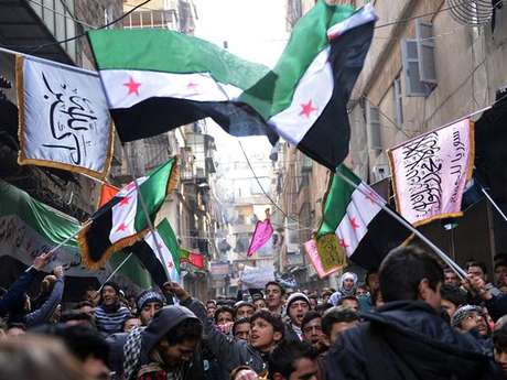 Rebeldes marcham em Aleppo, cidade-berço da revolta síria, com a bandeira da Síria usada antes de Assad e adotada pela oposição ao regime <p>Rebeldes marcham em Aleppo, cidade-berço da revolta síria, com a bandeira da Síria usada antes de Assad e adotada pela oposição ao regime</p>