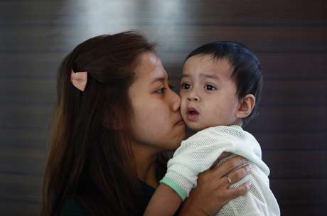 Reuters <p>Erny Khairul, mulher do engenheiro de voo Mohd Selamat, a bordo no avião desaparecido beija sua filha em hotel, onde esperam notícias sobre avião em Putrajaya</p>