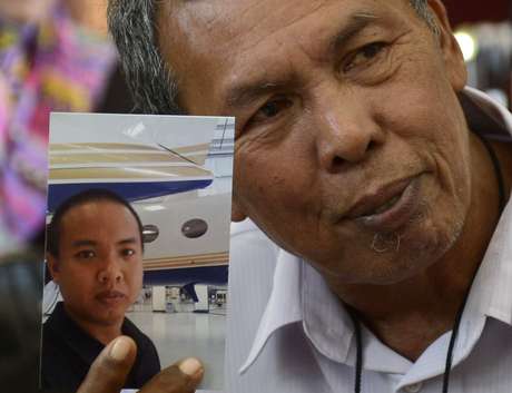 Reuters <p>O pai de Mohd Selamat mostra a foto do filho que estava a bordo do avião desaparecido. A polícia do país investiga possível participação do engenheiro na mudança de rota do Boeing</p>