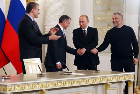 O presidente russo, Vladimir Putin, aperta a mão dos líderes da Crimeia e de Sevastopol após a assinatura de um tratado para anexar a Crimeia àa Rússia, nesta terça-feira, no Kremlin, em Moscou <p>O presidente russo, Vladimir Putin, aperta a mão dos líderes da Crimeia e de Sevastopol após a assinatura de um tratado para anexar a Crimeia àa Rússia, nesta terça-feira, no Kremlin, em Moscou</p>