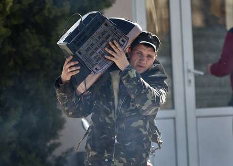 Soldado ucraniano carrega uma televisão enquanto deixa a base militar de Belbek, perto de Sebastopol, Crimeia, nesta sexta-feira Soldado ucraniano carrega uma televisão enquanto deixa a base militar de Belbek, perto de Sebastopol, Crimeia, nesta sexta-feira