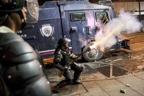 Agentes da Guarda Nacional Bolivariana enfrentam grupos de manifestantes em Caracas, em 3 de abril Agentes da Guarda Nacional Bolivariana enfrentam grupos de manifestantes em Caracas, em 3 de abril