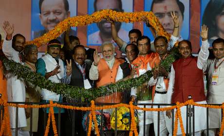 O candidato a primeiro-ministro do partido da oposição, Narendra Modi, é coroado em sua chegada a um comício eleitoral em Nova Déli, em 26 de março <p>O candidato a primeiro-ministro do partido da oposição, Narendra Modi, é coroado em sua chegada a um comício eleitoral em Nova Déli, em 26 de março</p>