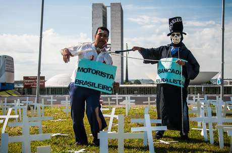 Manifestantes utilizam cruzes, fantasias e cartazes durante protesto Manifestantes utilizam cruzes, fantasias e cartazes durante protesto